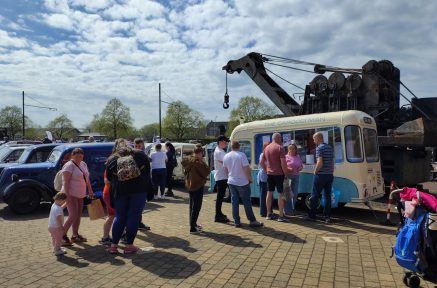 People queue at a vintage-style ice cream van at Summerlee Museum on a sunny day.